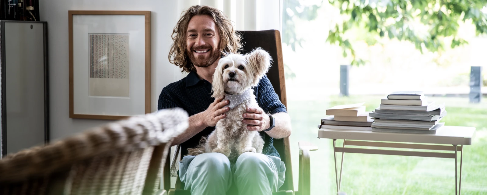Man with a funny dog on his lap in his home